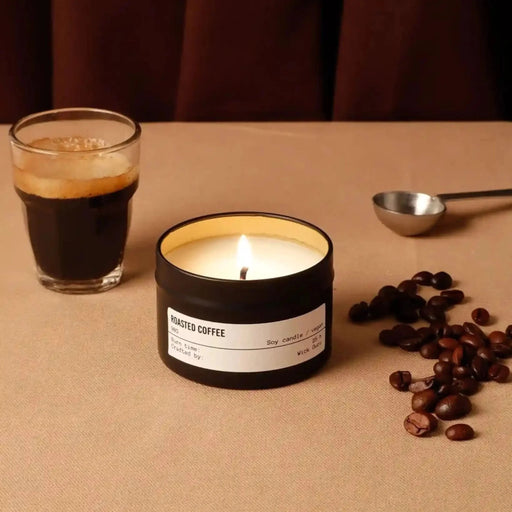Candle labeled 'Roasted Coffee' with a glass of coffee and coffee beans on a brown surface