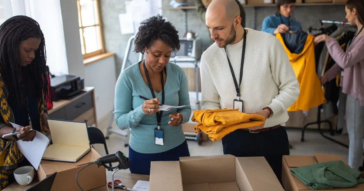 People working in a warehouse or distribution center, packaging items into boxes.